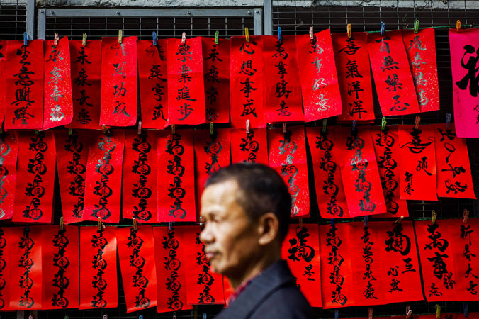 A man walks past Chinese New Year's calligraphy displayed along a street of Hong Kong. ?Photo by AFP