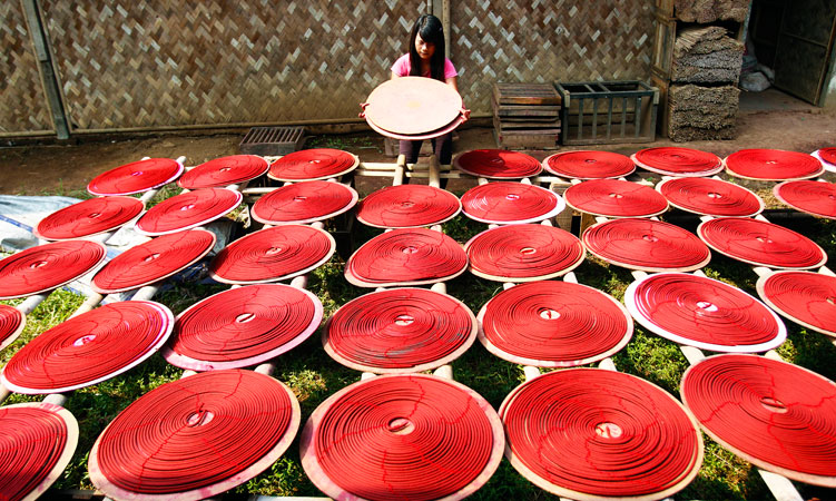 An Indonesian worker dries colored circle incense sticks prepared for Chinese New Year celebrations, in Tangerang on the outskirts of Jakarta, Indonesia. ?Photo by AP