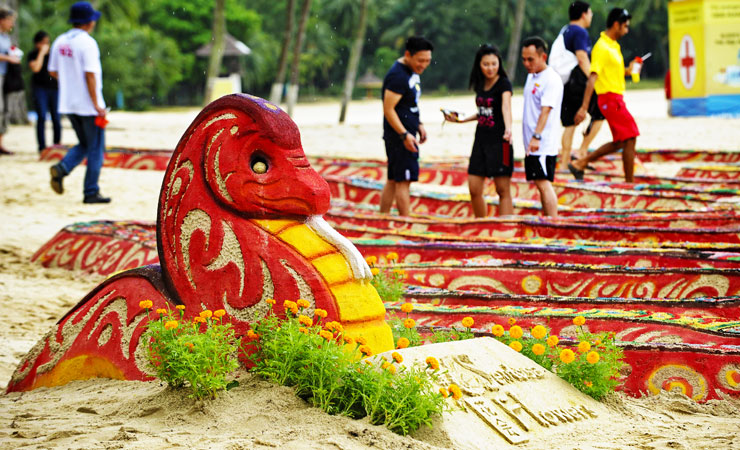 Volunteers give the finishing touches to a snake sand sculpture exhibited at the first sandy spring floral festival on Sentosa Island's Palawan beach off Singapore. The exhibition also features Chinese zodiac animals to celebrate the Lunar New Year. ?Photo by AFP