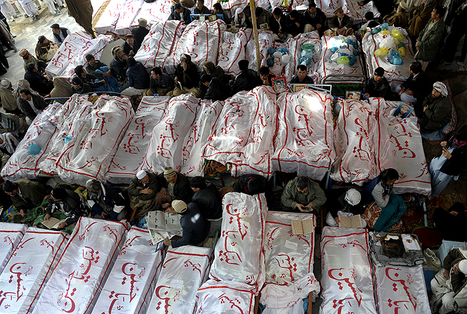 Pakistani Shia Muslims gather around the coffins of bomb attack victims as they demonstrate in Quetta on February 18, 2013. ? AFP Photo