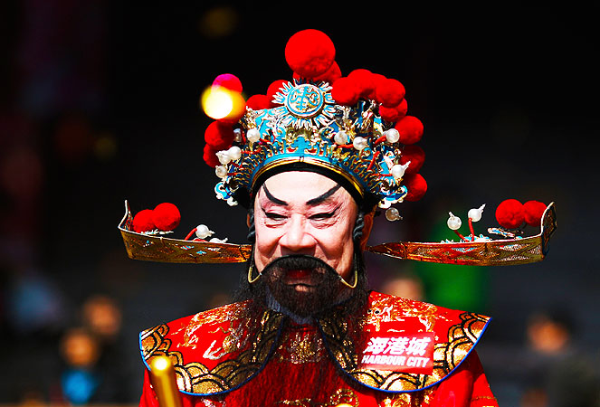 A man dressed as The God of Wealth poses for a picture outside a shopping mall in Hong Kong. ?Photo by AP