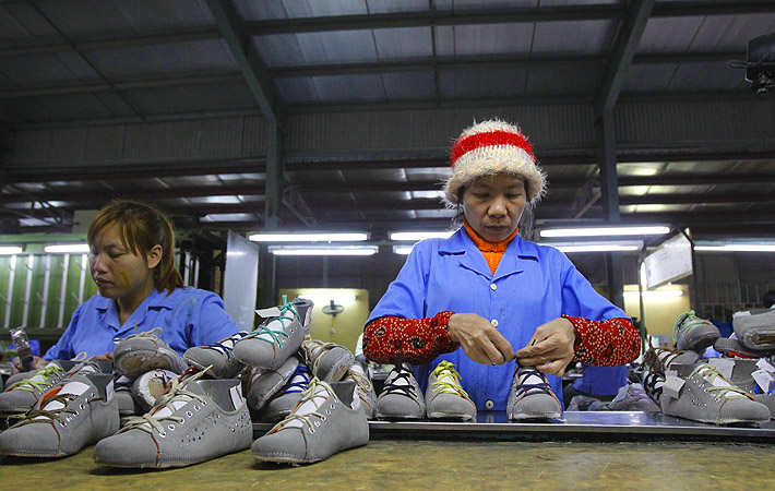 Employees work on an assembly line at a shoe factory in Tan Lap village, outside Hanoi. Vietnam has approved a broad plan to boost its economy to 2020, focusing on restructuring public investment, banks and state-owned enterprises while controlling inflation and maintaining growth.