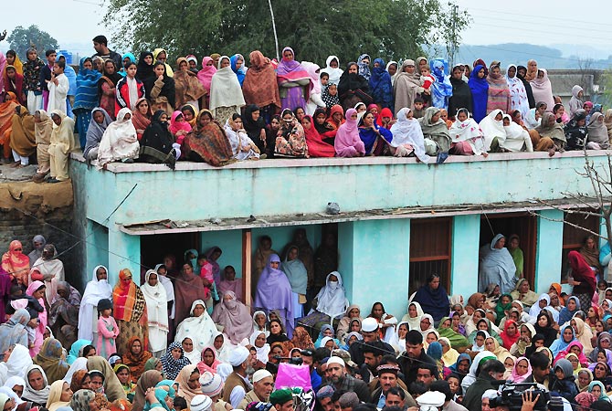 Villagers gather for the funeral. -Photo by AFP