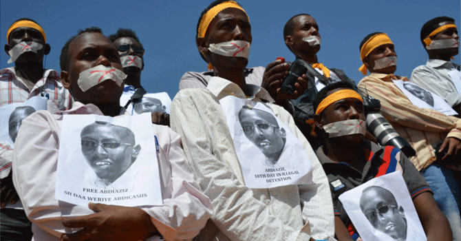 Somali journalists simulate an arrest protest for their colleage, Abdiaziz Abdinor Ibrahim, who was arrested and accused of reporting a false rape and giving the woman a bribe to lie. - Photo by AFP