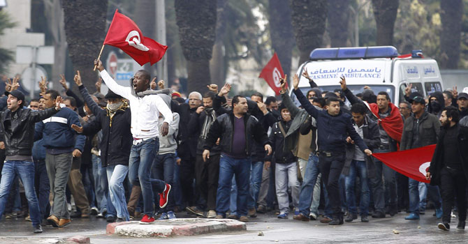 Protesters gesture to the police during a demonstration in Tunis February 6, 2013. — Photo Reuters