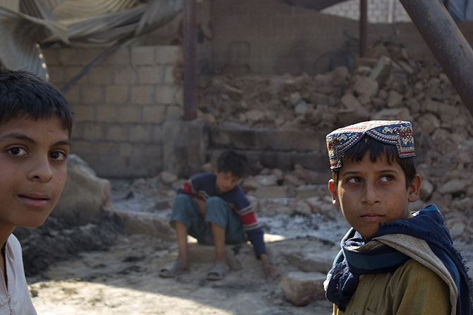 Children from around the neighborhood, stand near what used to be row after row of shops and stalls.