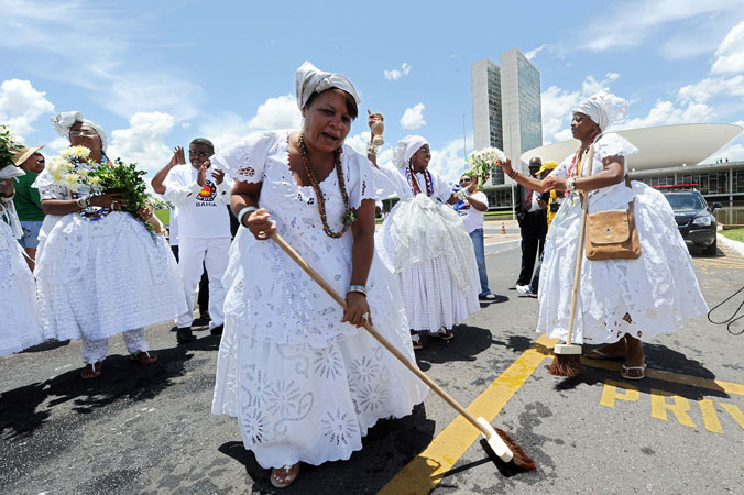 A group of Baianas wearing traditional clothes make ?a cleaning? against negative energies and corruption before the National Congress during the 7th March of the Workers Unions and Social Movements in Brasilia. ?Photo by AFP