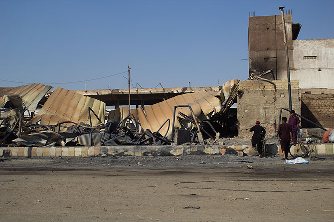 Children walking towards the charred roof of the New Sabzimandi.