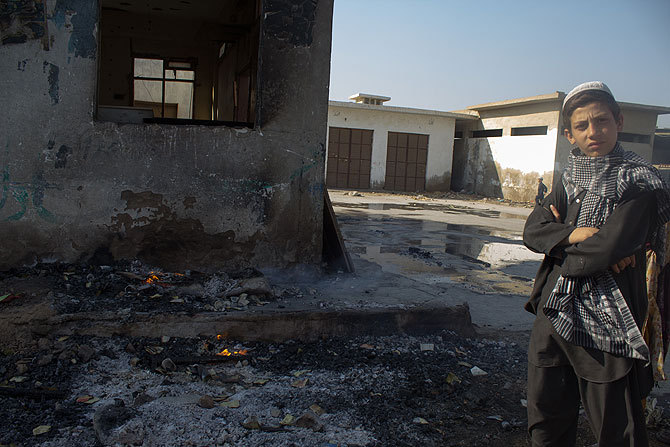 A boy stands in front of a madrassa that also caught fire during the blaze that erupted on Tuesday.