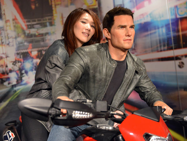 A woman sits on a motorbike with the wax figure of Hollywood star Tom Cruise. ?Photo by AFP