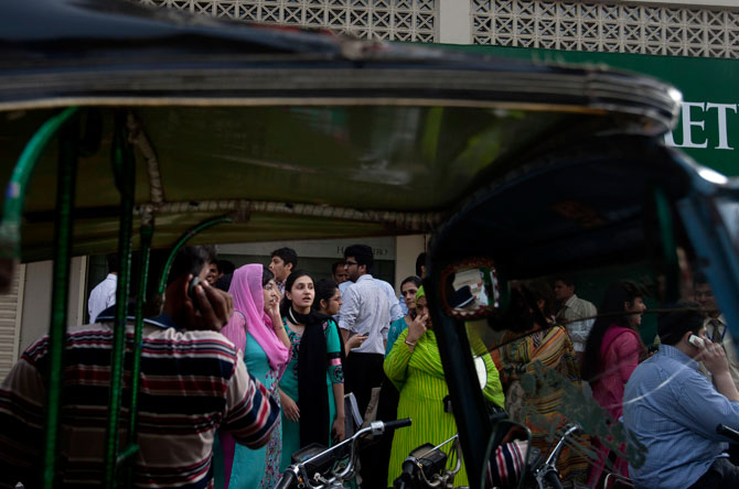 People evacuate buildings and gather on road after a tremor of an earthquake was felt in Karachi.