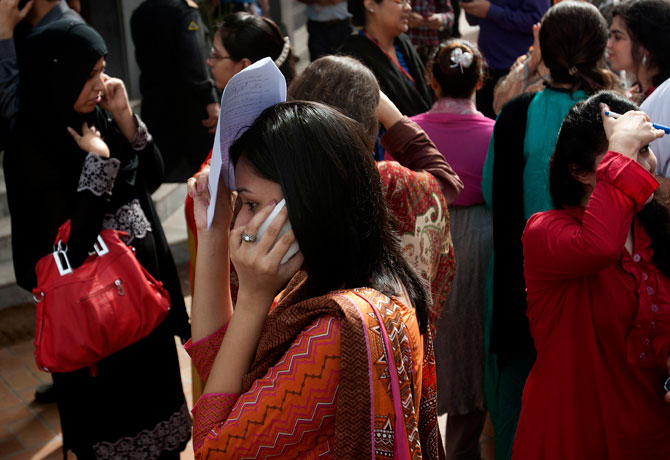People evacuate buildings and call their relatives after a tremor of an earthquake was felt in Karachi, Pakistan.