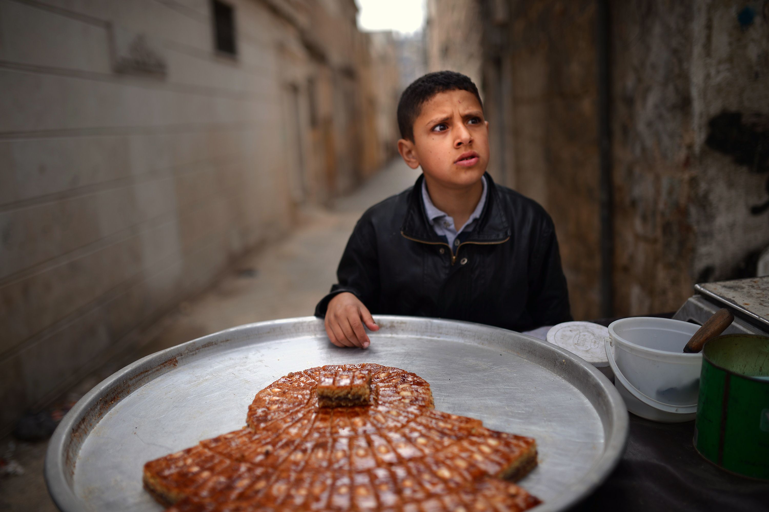 A Syrian boy sells sweets in the northern Syrian city of Aleppo on April 6, 2013. Conflict in neighbourhoods of Aleppo, which has been shaken by war for nine months, has put an end to childhood for most youths and it is not uncommon to see young boys working in the streets.