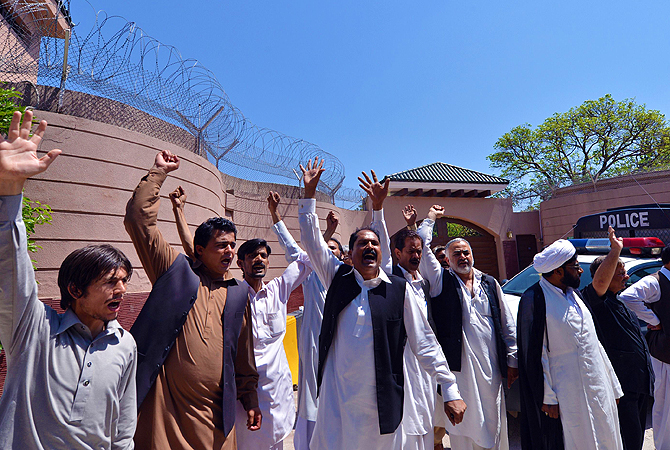 Supporters of former Pakistani president Pervez Musharraf shout slogans outside his residence after a court ordered for his arrest in Islamabad on April 18, 2013.