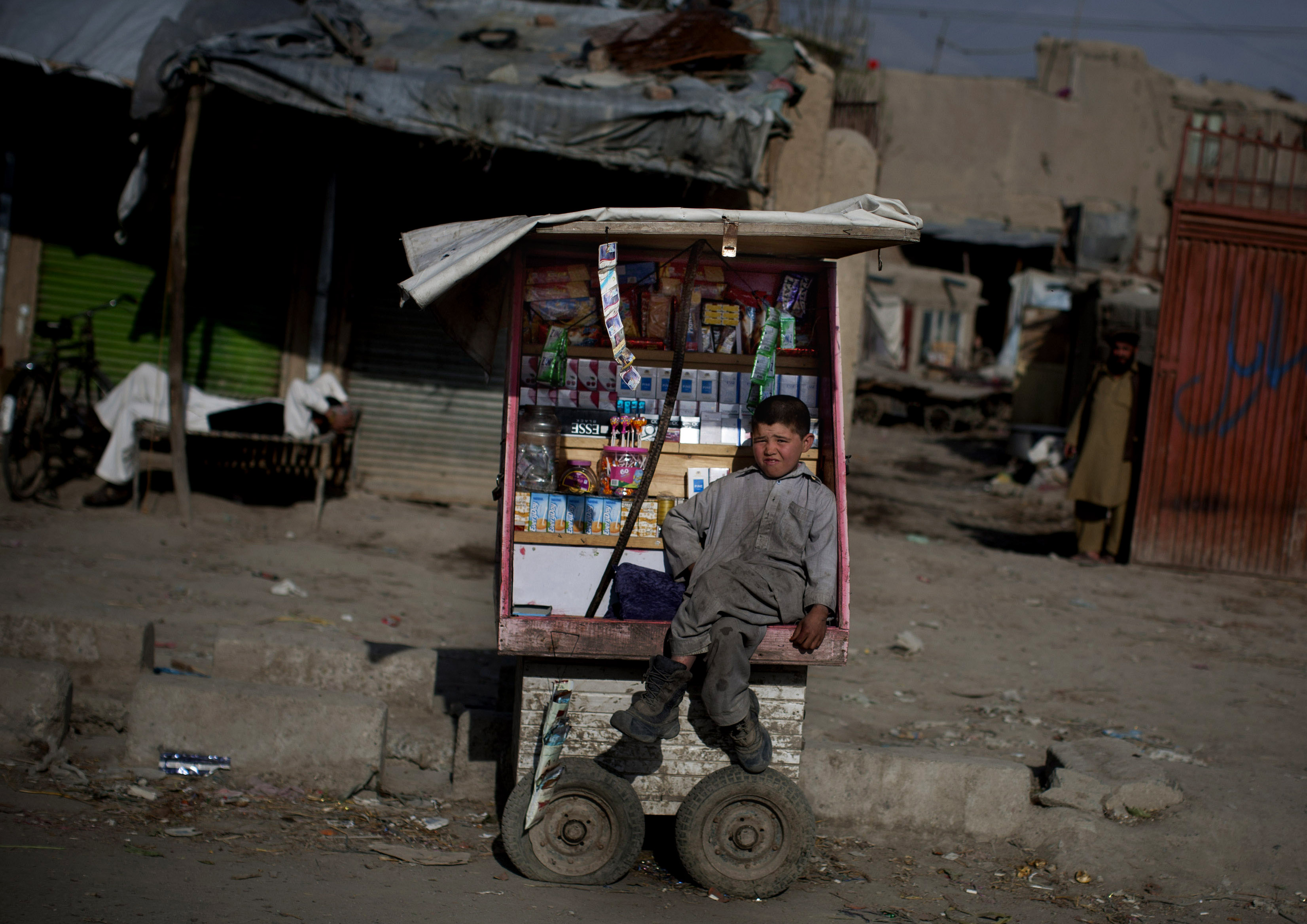 An Afghan boy sits on his cart as he waits for customers in the old town of Kabul, Afghanistan, Sunday, April 7, 2013.