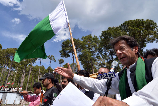 Imran Khan (R) addresses supporters.