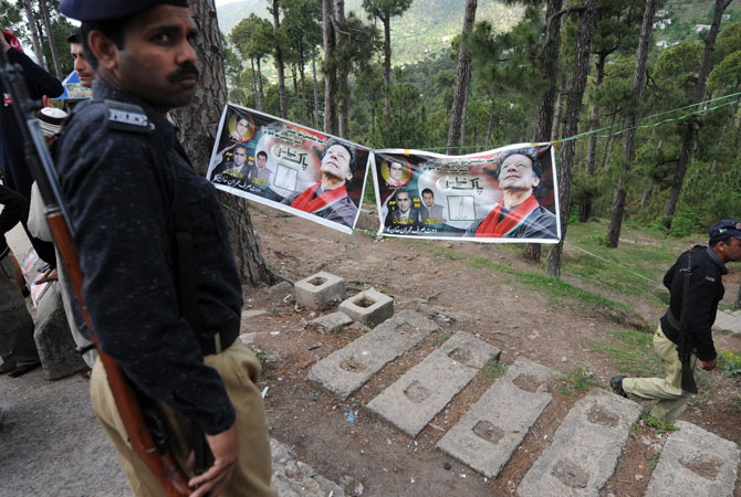 Pakistani policemen stand guard during the general election campaign meeting organised by Imran Khan in Murree on April 29, 2013.
