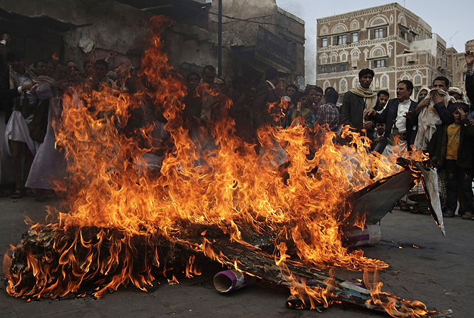 Supporters of the Yemeni al-Houthi Shia rebel group burn an effigy of a US aircraft during a demonstration to protest against US and Saudi interference in Yemen, after Friday prayer in Sanaa, Yemen.