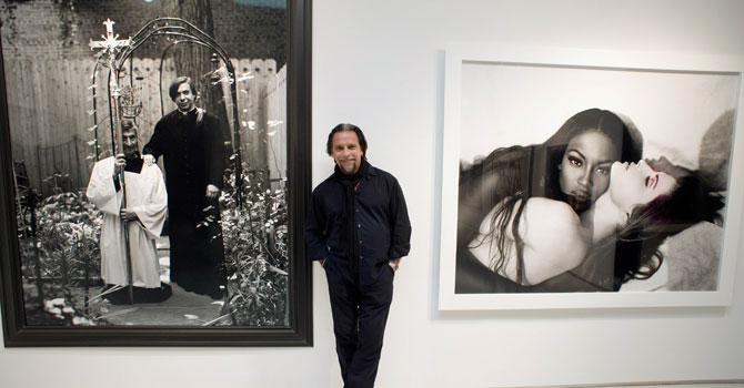 Photographer Sante D’Orazio poses between two of his photographs at Christie's in New York. D'Orazio's photos are part of “Photographs Week at Christie's”. —Photo by AFP