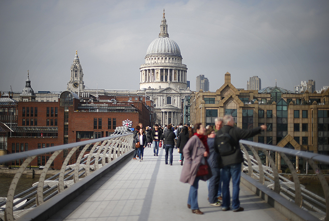 Two women walk along the Millennium footbridge crossing the River Thames towards St Paul's Cathedral in central London. The ceremonial funeral for Britain's late former prime minister Margaret Thatcher will be held at St Paul's next Wednesday.