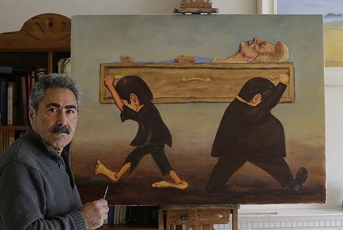 Political painter Kaya Mar, 56, poses for a photographer with his latest painting depicting the funeral of former British Prime Minister Margaret Thatcher at his home in London. According to the artist, the scene is depicted by a member of the working class, left, that was affected by her policies, and carries her coffin one way, while a member of the finance sector, right, who benefited, carry it the other way, depicting the divisions she created in the society. Thatcher, the combative "Iron Lady" who infuriated E