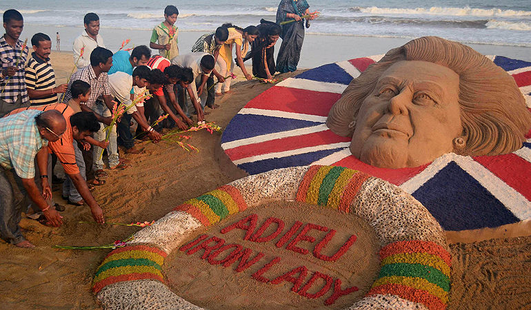 Indians pay tribute beside a sand sculpture of former British prime minister Margaret Thatcher, made by sand artist Sudersan Pattnaik, at the Golden Sea beach in Puri, about 65 kilometers from the eastern Indian city of Bhubaneswar. Britain will hold the funeral of former prime minister Margaret Thatcher on Wednesday April 17 with Queen Elizabeth II leading the mourners, officials said, as the country wrestled with deeply divided views of the "Iron Lady."