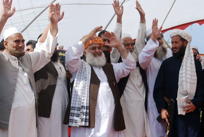 Maulana Fazalur Rehman (C, in brown vest), chief of the Islamic party Jamiat-e- Ulema Islam (JUI), waves to supporters during a parliamentary election campaign rally in the northwestern town of Mansehra on May 6, 2013.