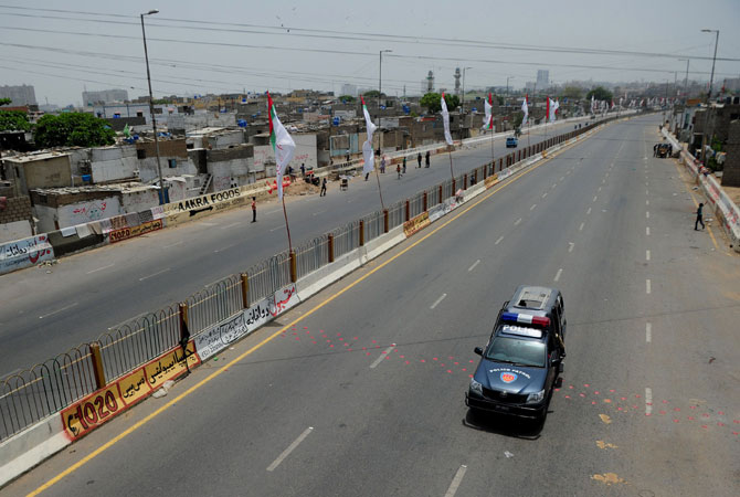 A Pakistani police van drives down the road during a strike in Karachi on May 5, 2013, a day after a bomb explosion near an office of the Muttahida Qaumi Movement (MQM). Three people were killed and 35 others wounded in twin bomb blasts near a local party office in the southern city of Karachi late Saturday, police said, ahead of next week's historic elections.