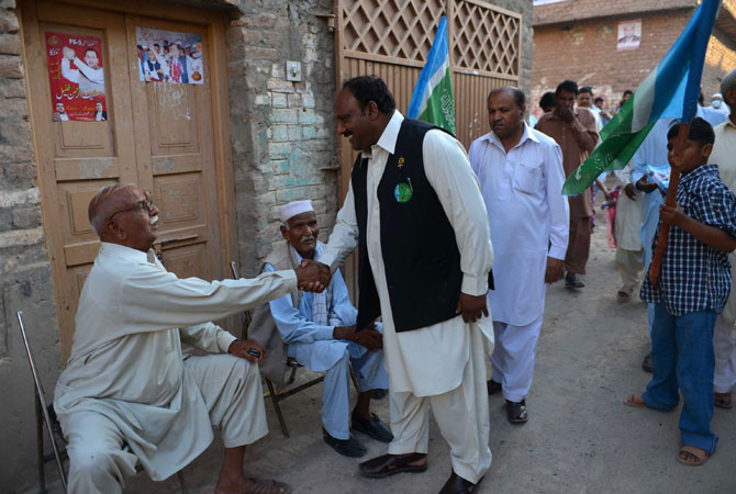 Pervaiz Masih (C), a Christian candidate of the Jamaat-e-Islami party for general election, meets with people at his election area in Peshawar.