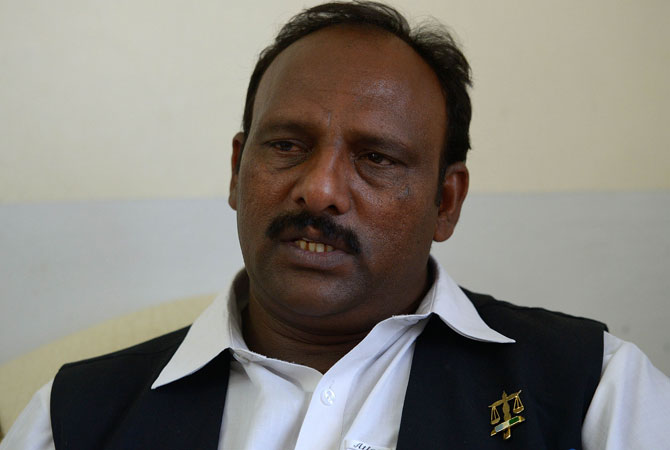 Pervaiz Masih (C) gives an interview to AFP in Peshawar.