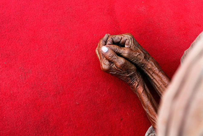 An elderly Indian widow prays during a function organized by Sulabh International on the bank of Holy River Ganga in Varanasi, India, Sunday, April 28, 2013. In India, being a widow remains one of the worst stigmas. When her husband dies, the widow often becomes a pariah, excluded from family gatherings for fear the mere fall of her shadow will bring bad luck and tragedy. In the North, many journey to the holy cities of Vrindavan and Varanasi, where they beg, and are paid a pittance to recite prayers in the temple