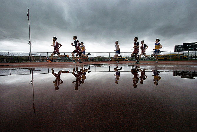 A pack of runners from Valley View High School and Scranton High School sprint past a rain puddle during the 800-meter event during athletics meet at Scranton High School on Monday, April 29, 2013 in Scranton, Pa. — AP Photo