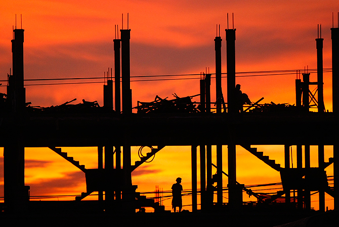 Local workers wake up at a construction site in Koak Khleang village where they are currently sleeping, in Phnom Penh, Cambodia, Sunday, May 12, 2013. — AP Photo