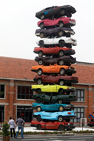 Visitors look at an art form made by piles of colorful scraped cars, entitled "2013 Rebirth" on display at an art zone renovated from an old factory in Wuhan in central China's Hubei province Friday, May 10, 2013. — AP Photo
