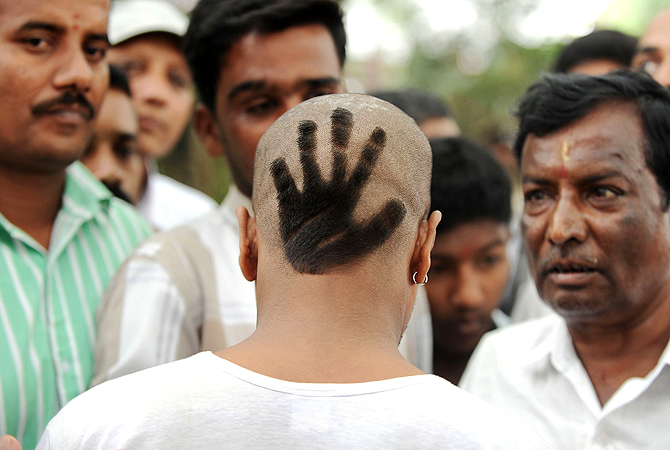 A Congress Party supporter displays his hair style featuring the party's symbol at the swearing-in ceremony of Karnataka Pradesh Congress Committee (KPCC) chief, Siddaramaiah as Karnataka chief minister in Bangalore on May 13, 2013. Congress leader Siddaramaiah takes over as 22nd Karnataka chief minister after leading his party to a huge win in last week's assembly elections, winning 121 seats in the 224-seat assembly. — AFP Photo