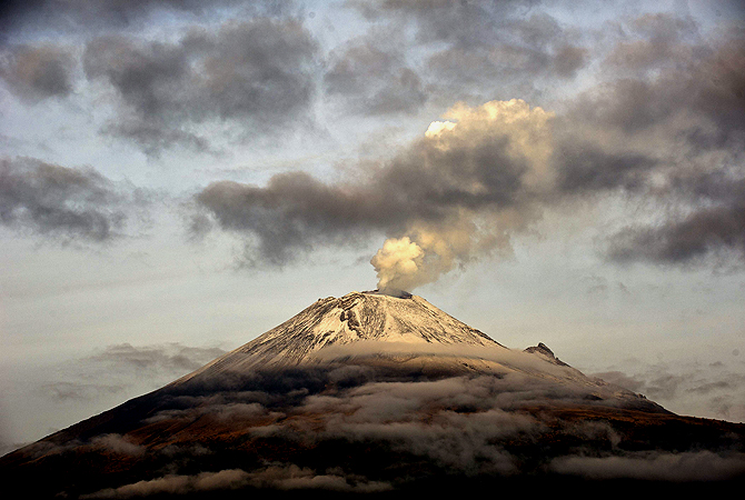 The Popocatepetl Volcano, Mexico's second highest peak just 55 km southeast of Mexico City, is seen from Santiago Xalitxintla, in Puebla, on May 14, 2013 spewing a cloud of ash and smoke. The National Disaster Prevention Centre (CENAPRED) raised the alert level on Sunday to "yellow phase three". — AFP Photo