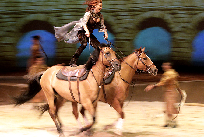 Fairland Ferguson rides while standing on the backs of a pair of horses during a dress rehearsal for the show "Cavalia" in Sydney. — AP Photo