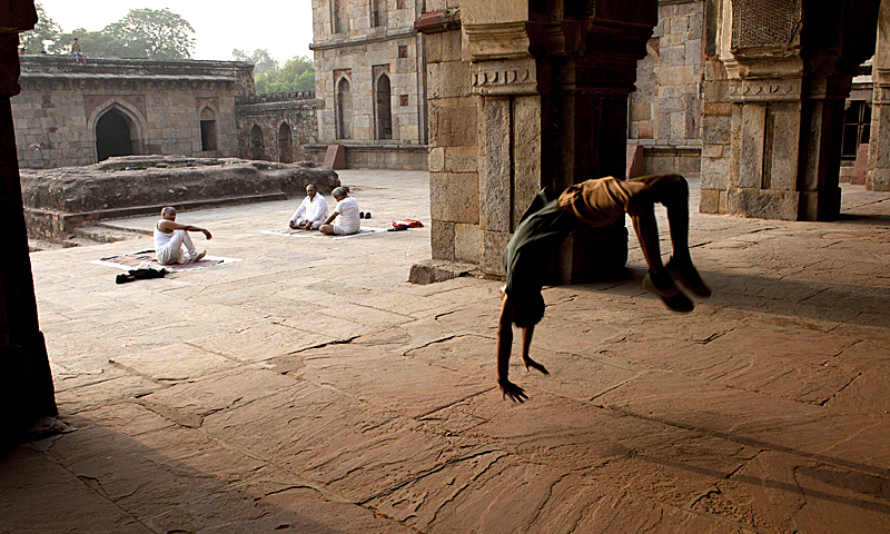 Indian dancer Om Dubey, 20, practices his moves as elderly yoga practitioners sit in the courtyard in front of the Three Domed Mosque and the Bada Gumbad monument, built during the reign of Sikander Lodi in 1494, at Lodi Gardens in New Delhi on May 7, 2013. India's youth, comprising some 41 per cent of its 1.2 billion population based on a 2001 census; represent what population experts call the "demographic dividend" of young workers that the government hopes will help power the country's economy. — AFP Photo