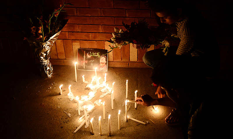 Supporters of Pakistani politician and former cricketer Imran Khan, light candles as they place flowers outside a hospital where Khan is admited in Lahore late May 7, 2013. Pakistani politician Imran Khan is being treated for a head injury after falling at an election rally, the latest dramatic turn in a campaign that has seen more than 100 people killed in attacks. — AFP Photo