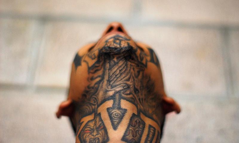 An imprisoned member of street gang Mara 18 poses for a photograph at the Izalco prison, about 65 km (40 miles) from San Salvador May 20, 2013. Inmates handed over handmade knives and more than 60 cell phones and other not-permitted articles in an effort to keep the truce between the country's two most powerful gangs Mara 18 and Mara Salvatrucha (MS-13), following a truce treaty signed by both sides in March 2012 to reduce violent crimes in the country. — Reuters Photo