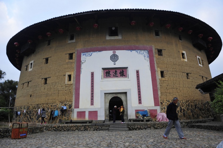 A man walks past Huaiyuan Lou, one of the best protected Fujian Tulou built in the year 1909, in Nanjing county, Fujian province, November 19, 2012. The earthen Tulou buildings, which set up enclosed walls to defend against outside dangers, have served the Hakka people since 11th century, when their ancestors settled down at the south west of Fujian province to escape from rule of Jin ethnic.