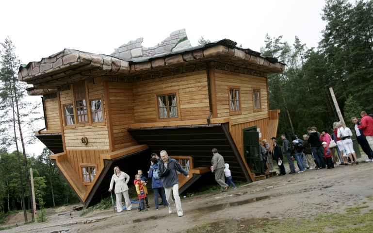 People wait in line to visit an upside-down house built at the Centre of Education and Promotion of the Region in the village of Szymbark, northern Poland July 31, 2007. The upside-down house created by Daniel Czapiewski is supposed to describe the times of the former communist era and the present times in which we live.