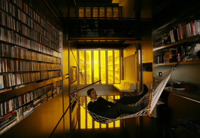 Hong Kong architect Gary Chang rests in a hammock inside his 32-square-metre apartment in Hong Kong January 28, 2010. After three decades in the same boxy dwelling Chang grew up in, he has come up with an innovative answer to the increasingly cramped lives of many urban dwellers -- the science fiction-like "domestic transformer". Picture taken January 28, 2010.
