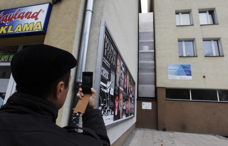 A man takes a picture of the one of the world's narrowest buildings, built as an artistic installation wedged between two existing buildings, in Warsaw October 23, 2012. A building just 92 cm (36 inches) wide as its narrowest point was opened in Warsaw on October 20 as an artistic installation that will be a home from home for Israeli writer Edgar Keret. Keret, who told news channel TVN24 he would live there when he visits Warsaw twice a year, said he conceived the project as a kind of memorial to his parents' fami