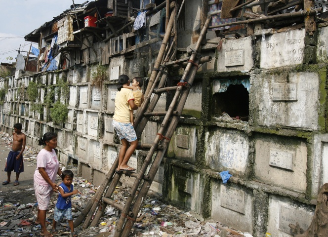 Residents climb into their houses atop gravestones inside a cemetery in Manila October 21, 2008. Many poor urban dwellers make their homes in public cemeteries, converting abandoned tombs and mausoleums into houses. The local government plan to move out the hundreds of people who live in the cemeteries around the city before the upcoming All Souls' Day, a day of remembrance for the dead when Catholics visit the graves of their relatives.