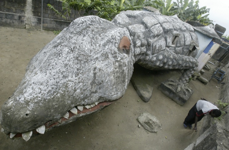 Thierry Atta sweeps the courtyard of his house built in the shape of a crocodile in Ivory Coast's capital Abidjan, September 11, 2008. Atta was an apprentice of the artist Moussa Kalo who designed and built the house but died two months ago.