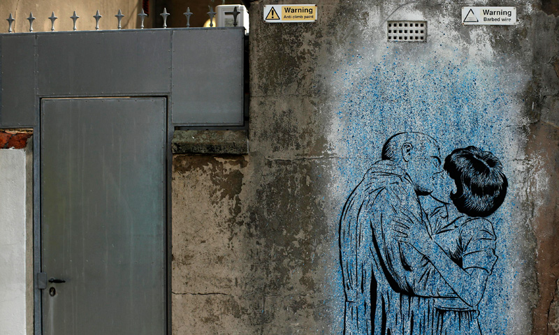 A man walks past murals painted on the wall of a car park in Blackpool, northern England June 18, 2013. The mural is part of the "Sand, Sea and Spray" outdoor art festival, which has seen 40 urban artists from around the world paint murals on buildings across the town centre. — Reuters Photo