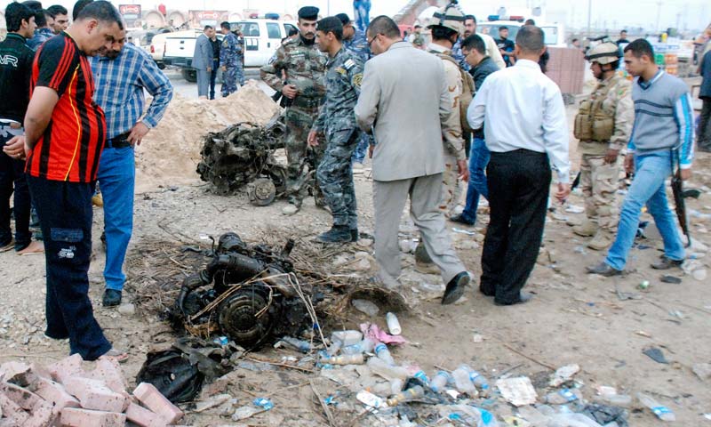 Iraqi security forces inspect the site of a car bomb attack in Kut, 150 km southeast of Baghdad. -Reuters Photo