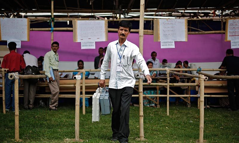 A polling officer carries an electronic voting machine (EVM) after collecting it from a distribution centre ahead of general elections in Jorhat district, in the northeastern Indian state of Assam. —Photo by Reuters