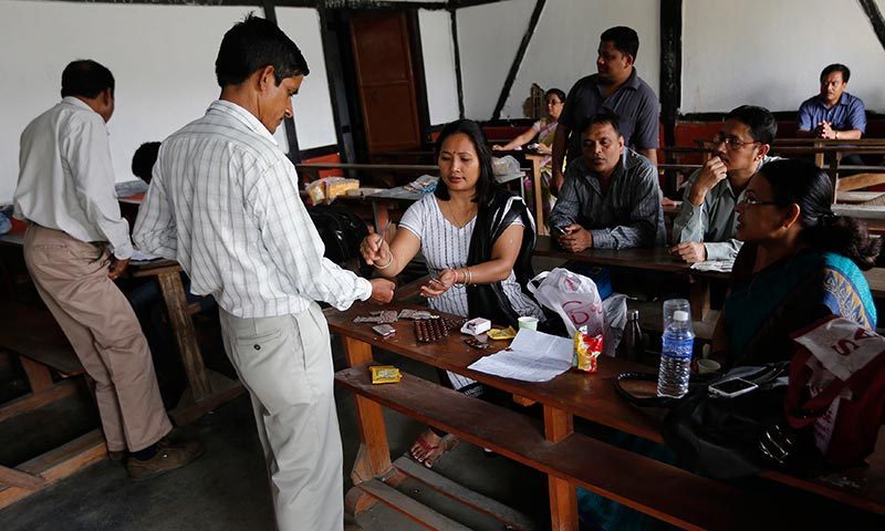 A polling officer collect medicine during a medical checkup, before leaving for his assigned polling station, at distribution centre ahead of general elections in Jorhat district, in the northeastern Indian state of Assam. —Photo by Reuters
